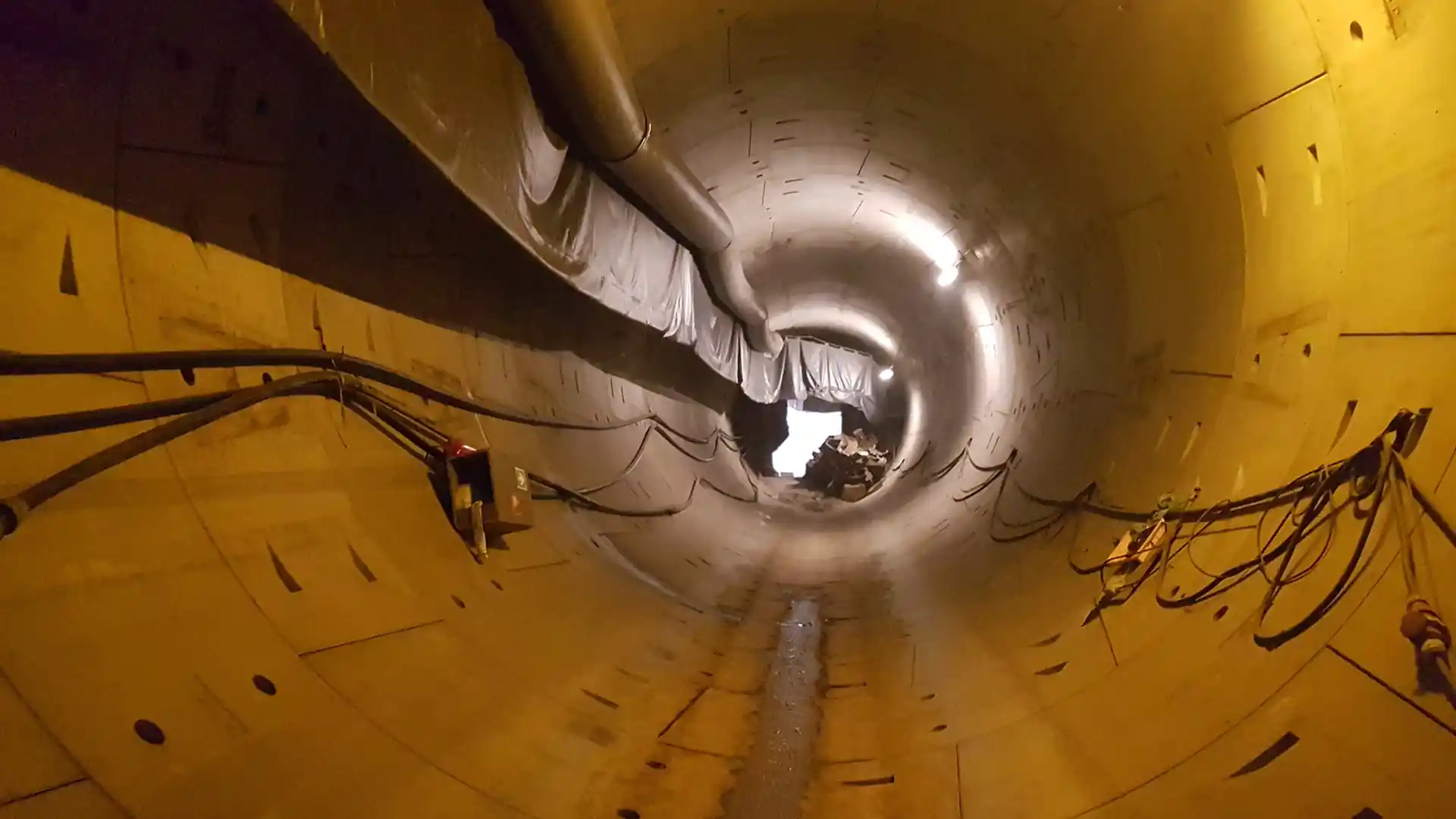 Blick in eine runde Tunnelröhre mit Kabeln