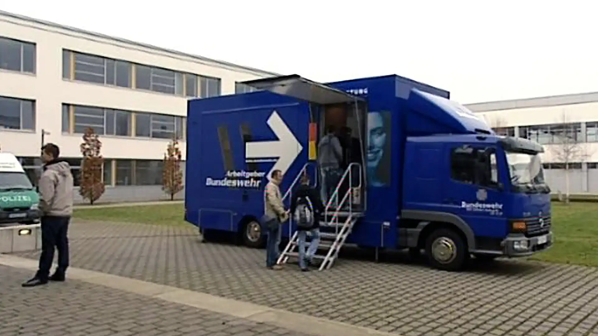 Lkw der Bundeswehr mit Beratungsangebot vor einem Kasernengebäude