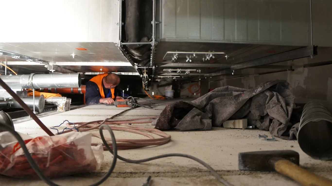 Baustelle im Inneren des Flughafenterminals BER mit Rohren und Planen