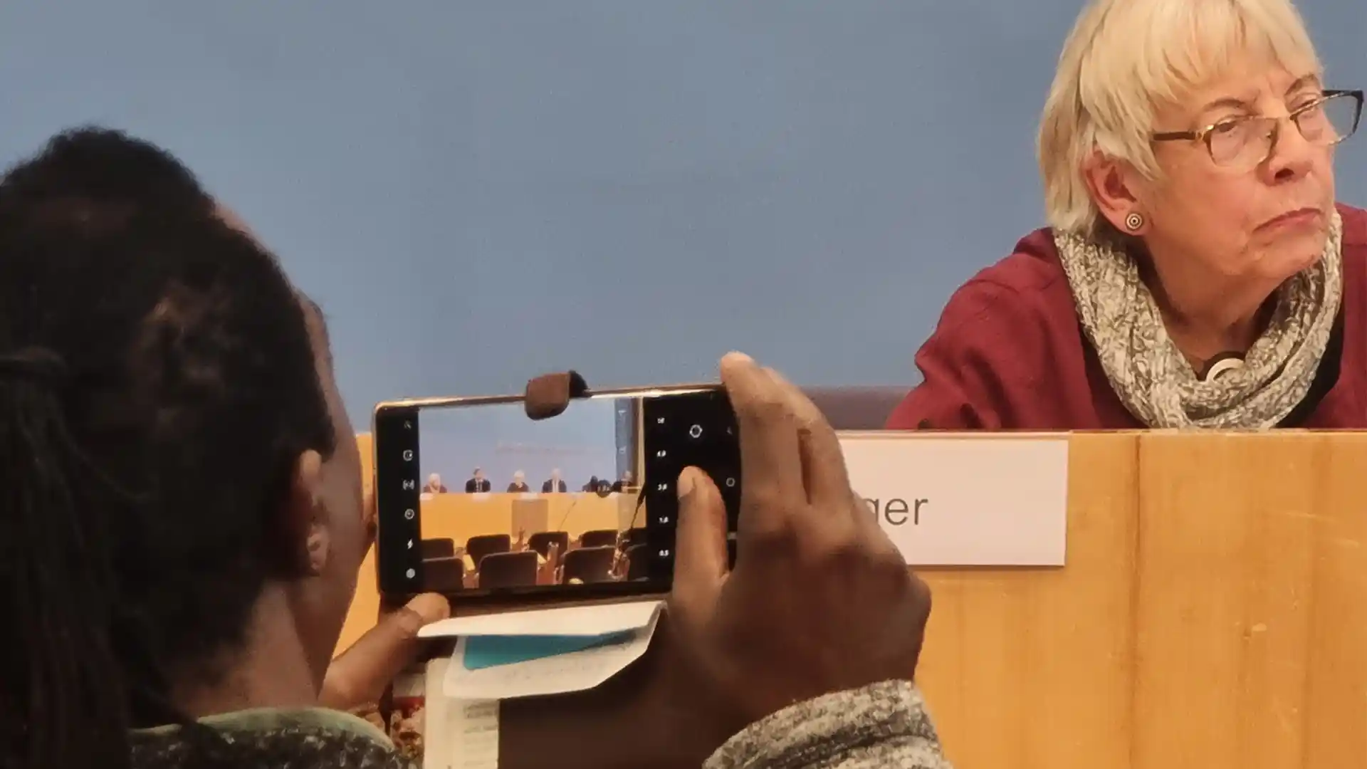 Almuth Berger am Rednerpult, im Vordergrund filmt eine Person mit dem Smartphone