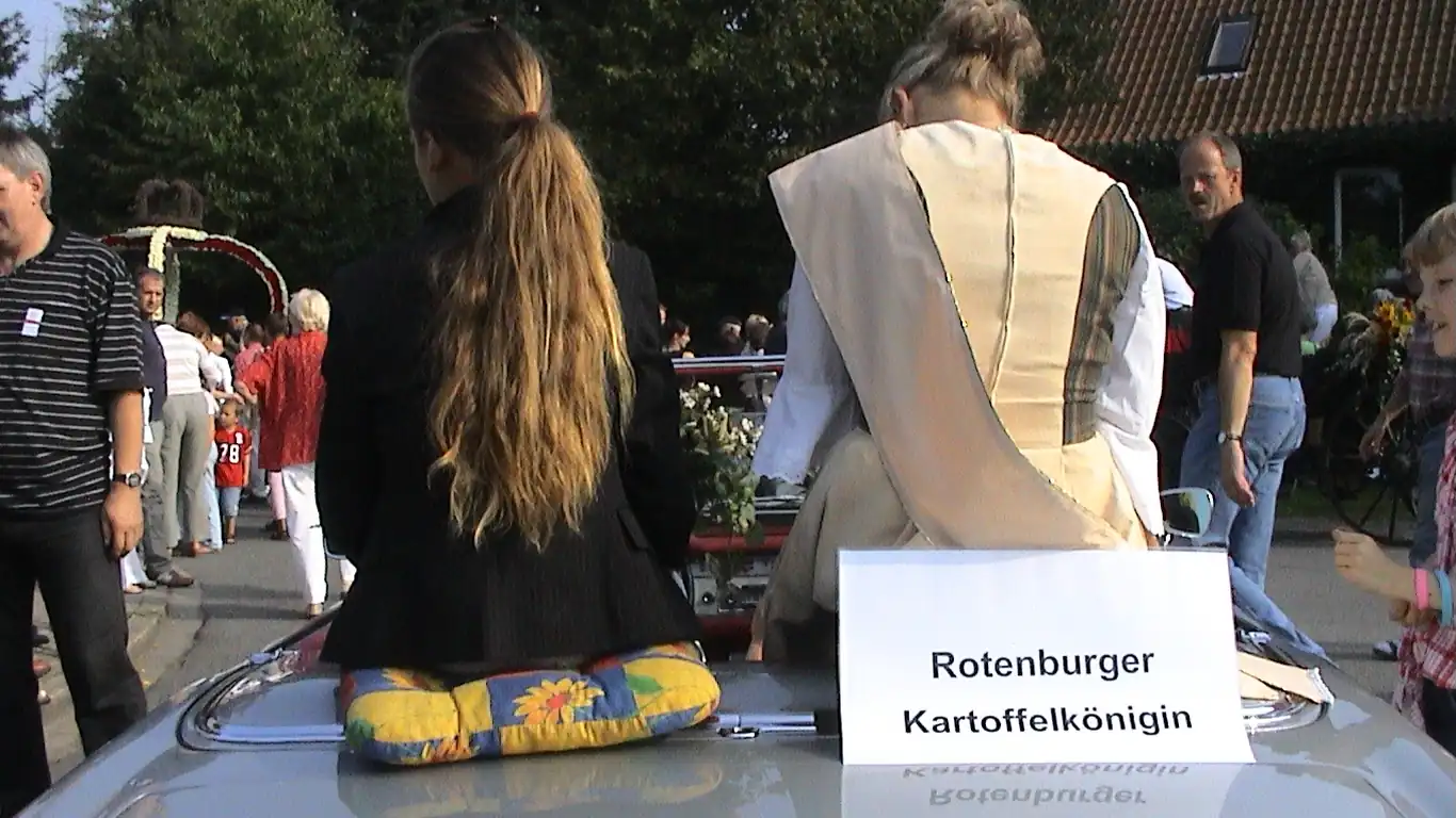 Zwei junge Frauen auf einem Autodach, davor das Schild Rotenburger Kartoffelkönigin