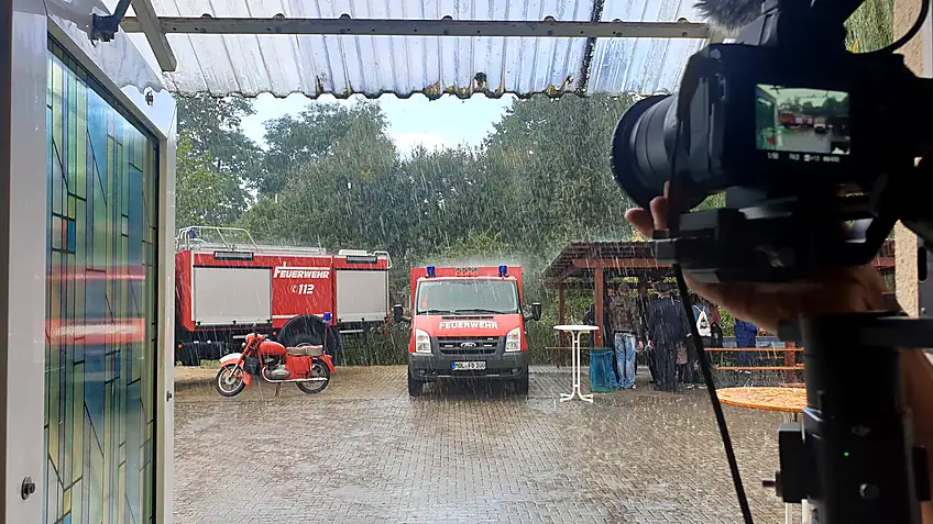 Feuerwehrfahrzeuge vor einem Pavillon im Regen